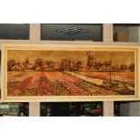 A CARPET PICTURE, depicting tulip fields and a windmill, circa 1970's, framed, size approximately