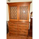 AN EDWARDIAN OAK AND WALNUT CABINET, moulded cornice above double doors with leaded glazing, the