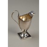 A GEORGE III SILVER PEDESTAL HELMET CREAM JUG, crimped rim, square foot, maker indistinct, London