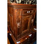 A GEORGIAN AND LATER OAK PANELLED SINGLE DOOR CABINET revealing an adapted interior, the door with