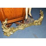 A VICTORIAN BRASS FENDER with foliate decoration and a pair of lions heads, maximum width 133cm