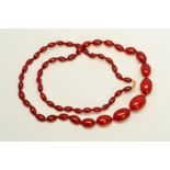 A RED PLASTIC BEAD NECKLACE, designed as graduated barrel shape beads measuring 12mm to 25mm, length