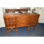 A 1920'S OAK SIDEBOARD, short raised back, the base fitted with three short drawers flanked by