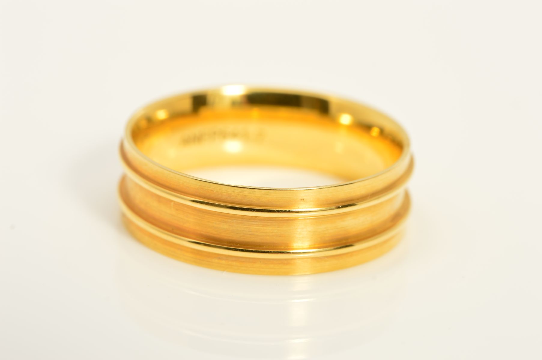 A MODERN 18CT YELLOW GOLD FLAT SECTION WEDDING BAND, with embossed line detail, measuring
