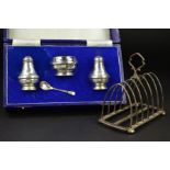 A GEORGE V SILVER SEVEN BAR TOAST RACK, arched form on a rectangular base with flattened bun feet,