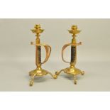 A PAIR OF BRASS CANDLESTICKS FORMED WITH VICTORIAN SWORD HILT STEMS, cylindrical candle holders