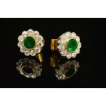 A PAIR OF EMERALD AND DIAMOND STUD CLUSTER EARRINGS, each designed as a central circular emerald