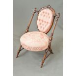 A LATE VICTORIAN WALNUT NURSING CHAIR, the arched back with foliate carved cresting rail above an