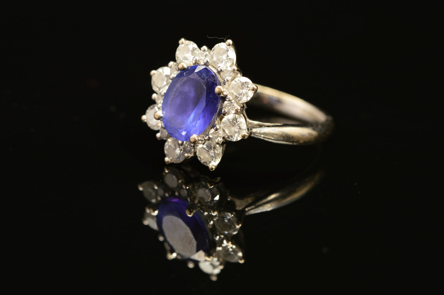 A MODERN 18CT WHITE GOLD TANZANITE AND DIAMOND OVAL CLUSTER RING, oval mixed cut tanzanite measuring