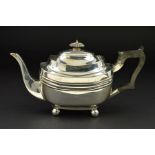 A GEORGE V SILVER BACHELOR'S TEAPOT, of shaped rectangular form, ebonised fitments and on four
