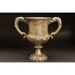 A VICTORIAN SILVER TWIN HANDLED TROPHY CUP, of urn form, repousse decorated with roses and thistles,