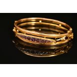 AN EARLY 20TH CENTURY 9CT GOLD AMETHYST AND DIAMOND HINGED BANGLE, designed as a navette shape panel