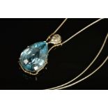 A MODERN 18CT WHITE GOLD LARGE BLUE TOPAZ AND DIAMOND PENDANT, claw set in an abstract mount,