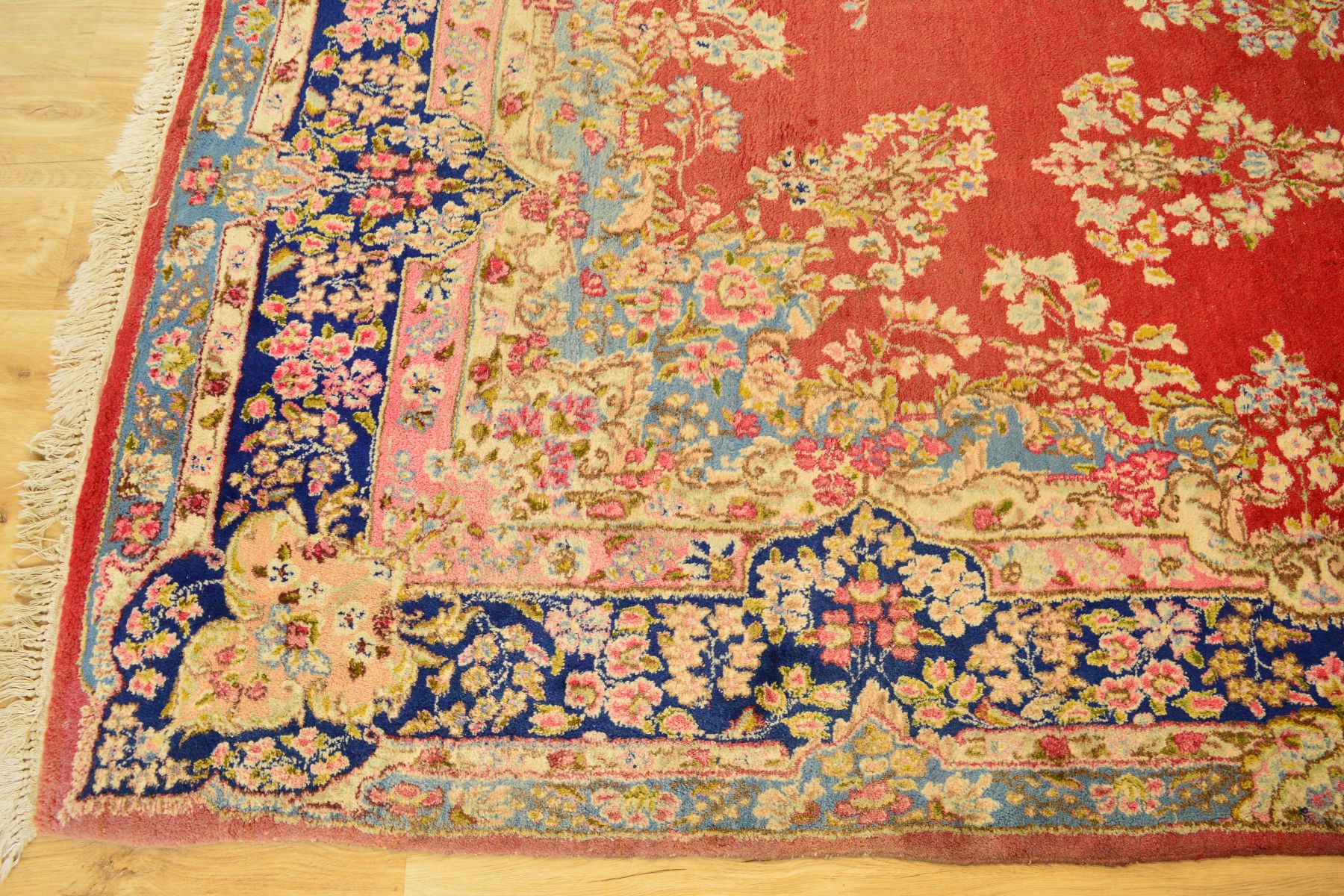 A LATE 19TH / EARLY 20TH CENTURY WOOLLEN CARPET, red ground with a deep border of foliate motifs and - Image 3 of 3