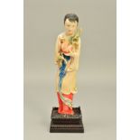 AN EARLY 20TH CENTURY JAPANESE CARVED IVORY FIGURE OF A GIRL HOLDING A POMEGRANATE, stained