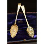 A CASED PAIR OF GEORGE IV SILVER GILT BERRY SPOONS, foliate chased handles engraved with initials '