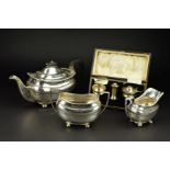 A GEORGE V SILVER THREE PIECE TEASET, of shaped rectangular form, gadrooned rims, ebonised fitments,