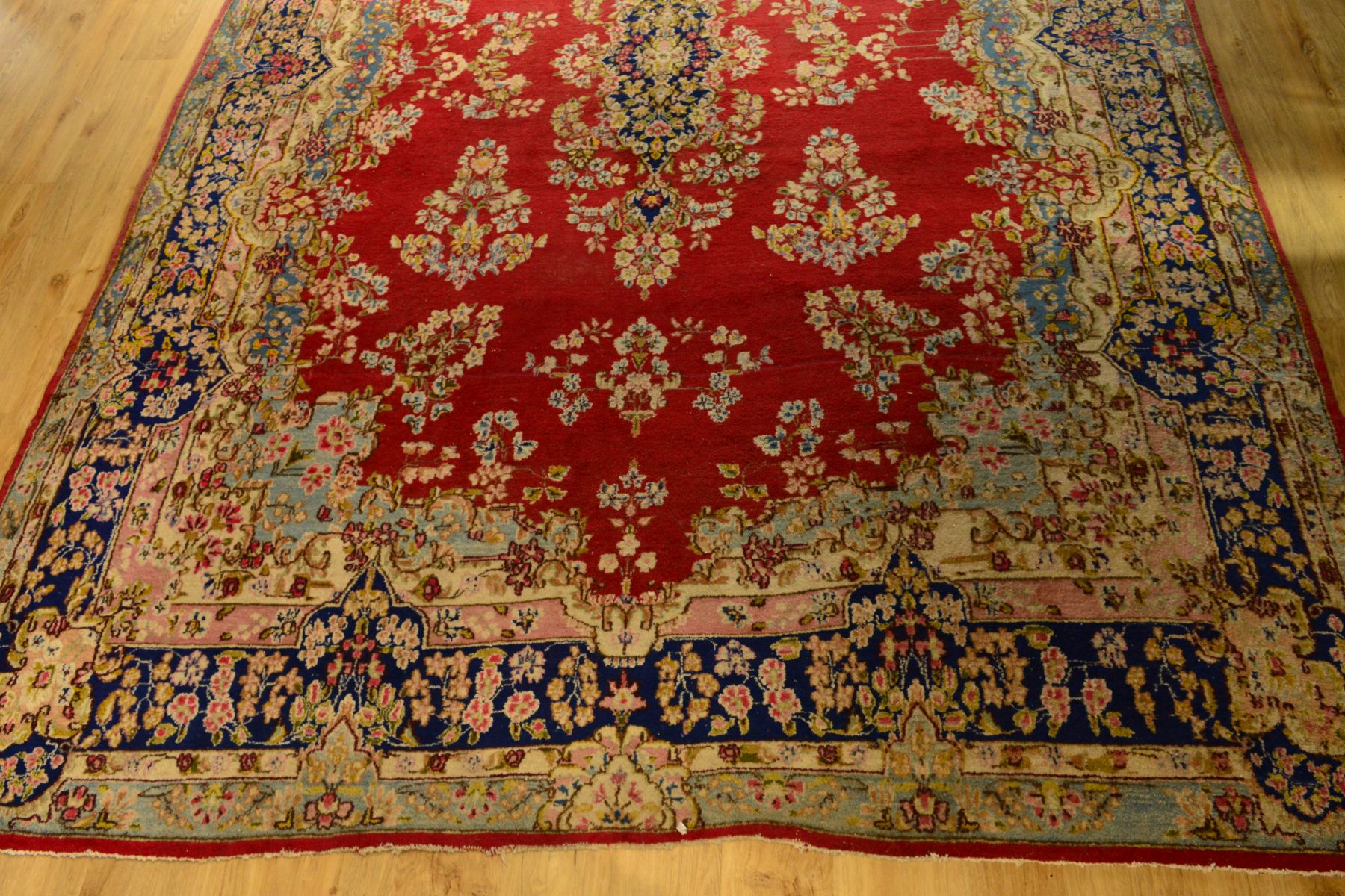 A LATE 19TH / EARLY 20TH CENTURY WOOLLEN CARPET, red ground with a deep border of foliate motifs and - Image 2 of 3