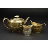 A LATE VICTORIAN SILVER BACHELOR'S THREE PIECE TEASET, of oval form, part reeded to lower half of