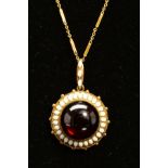 A MID VICTORIAN GOLD GARNET AND WHITE ENAMEL PENDANT, centring on a large cabochon circular garnet