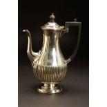 A VICTORIAN SILVER COFFEE POT, of baluster form, domed cover with ebony finial and handle, reeded to