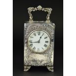 AN EDWARDIAN SILVER CASED BOUDOIR OR CARRIAGE TIMEPIECE, the top with hinged carrying handle cast