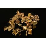 A 9CT GOLD CHARM BRACELET, the fancy link bracelet suspending a total of thirty charms, to include