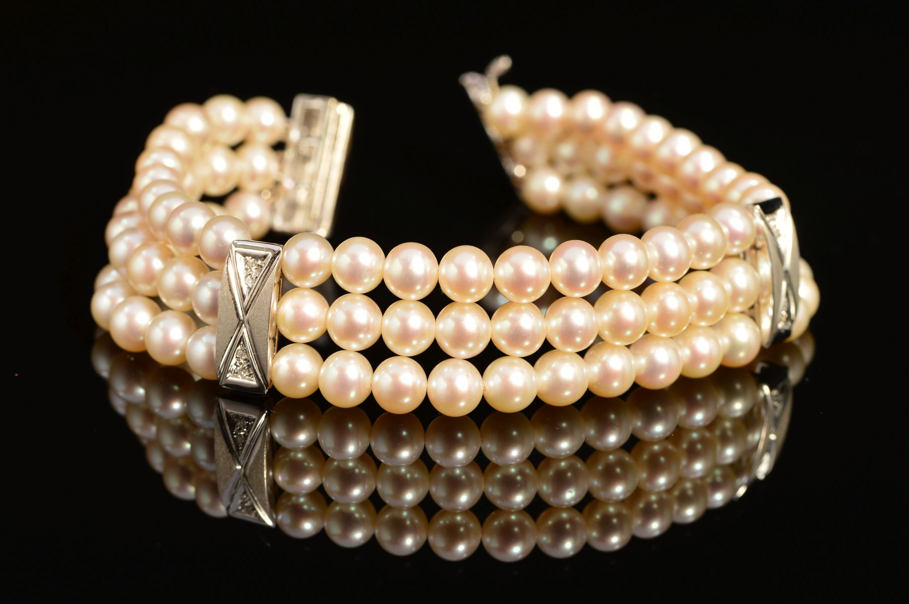 A MODERN 18CT WHITE GOLD, THREE ROW CULTURED PEARL AND DIAMOND BRACELET, each row intersected by a