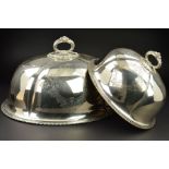 A GRADUATED SET OF TWO VICTORIAN SILVER PLATED OVAL MEAT DOMES, beaded and foliate cast handles,