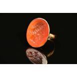 A CARNELIAN INTAGLIO RING, the oval carnelian carved to depict a bearded man, within a collet