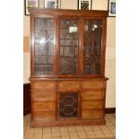 A LATE VICTORIAN OAK INVERTED BREAKFRONT BOOKCASE, the moulded cornice with dentil frieze above