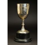 A GEORGE V SILVER TROPHY CUP, plain with knopped stem, mounted on a black plastic socle base, makers