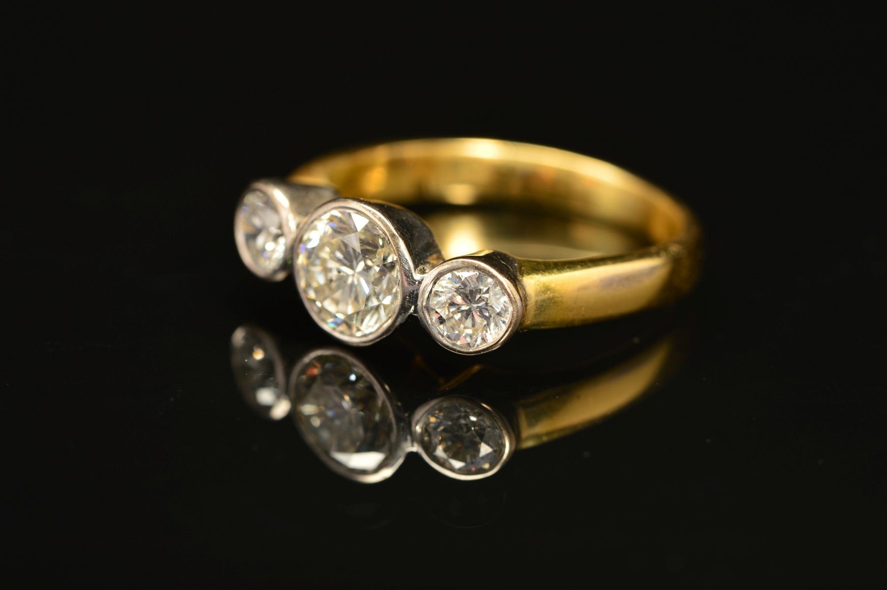 AN 18CT GOLD THREE STONE DIAMOND RING, designed as three brilliant cut diamonds within collet