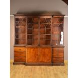 A GEORGE III STYLE MAHOGANY BREAKFRONT BOOKCASE, the moulded cornice with dentil frieze above four