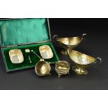 A PAIR OF VICTORIAN SILVER OVAL TWIN HANDLED PEDESTAL SALTS, worn gilt interiors, foliate repousse