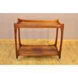 A 1970'S DANISH ROSEWOOD TWO TIER TEA TROLLEY, with a shaped framed on orbit casters, width 91cm x
