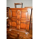 A REPRODUCTION OAK PANELLED FOUR DOOR CUPBOARD, width 84cm x depth 32cm x height 91.5cm