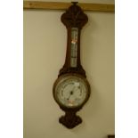 AN EDWARDIAN CARVED OAK ANEROID BAROMETER, height 84cm and a wall mirror (2)