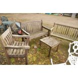 A TEAK SLATTED BRIDGEMAN GARDEN BENCH with a matching chair and coffee table, together with