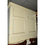 AN EARLY 20TH CENTURY PAINTED PINE PANELLED TWO DOOR CUPBOARD (key), a low chest of two drawers,