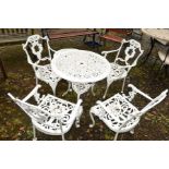 A WHITE PAINTED CIRCULAR ALUMINIUM GARDEN TABLE with floral design, four matching chairs and a