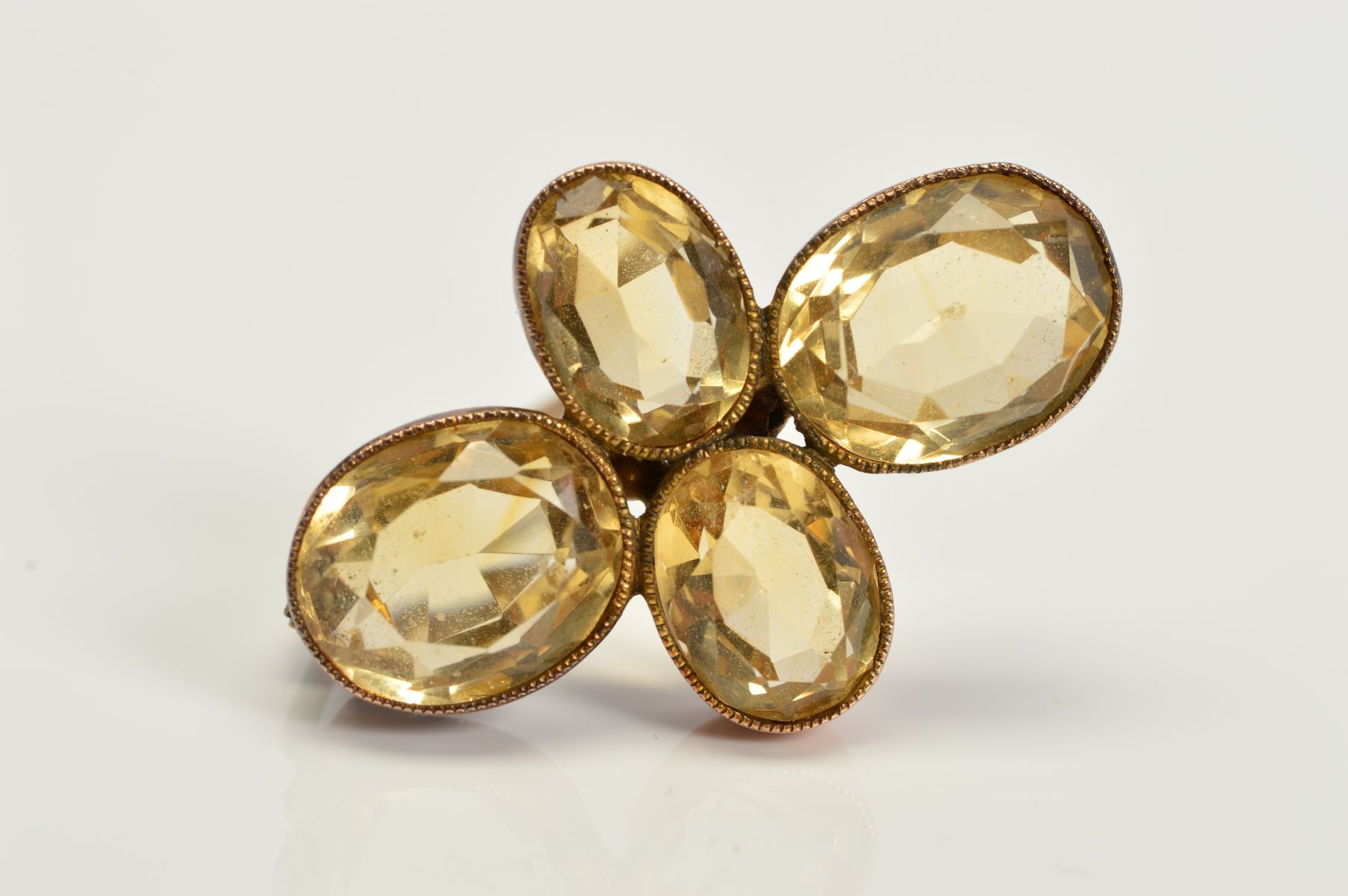AN EARLY 20TH CENTURY CITRINE QUATREFOIL DESIGN BROOCH, measuring approximately 30.0mm x 25.0mm,