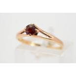 A 9CT GOLD GARNET RING, the circular garnet within a four claw setting to the bifurcated