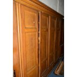 AN EARLY 19TH CENTURY SCUMBLED PINE PANELLED FOUR DOOR HOUSEKEEPERS CUPBOARD, overhanging cornice,