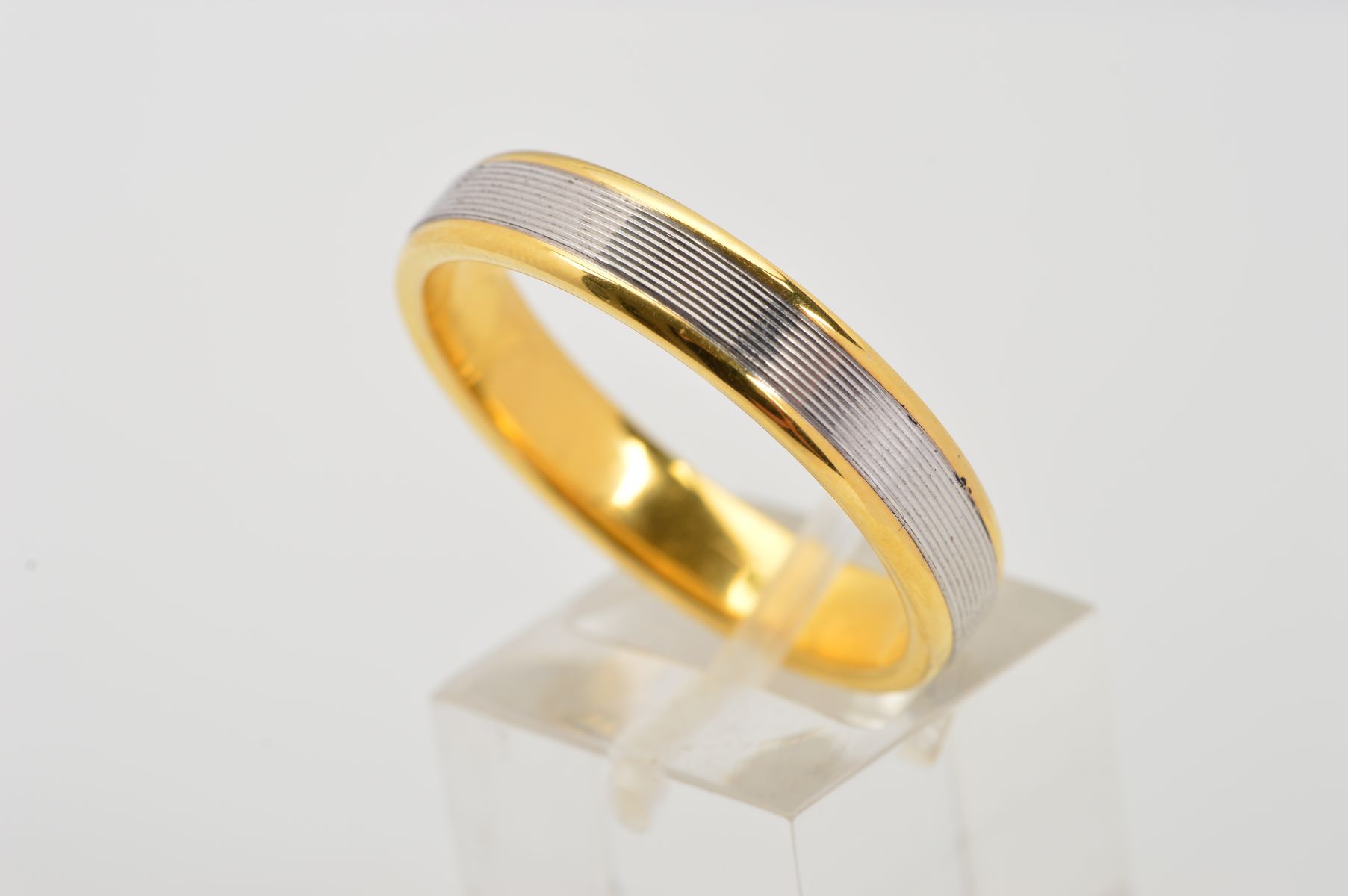 A MODERN 18CT YELLOW AND WHITE GOLD WEDDING RING, flat cross section, fine line detail, measuring