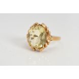 A CITRINE RING, the oval citrine within a laurel wreath style surround, hallmark rubbed, ring size