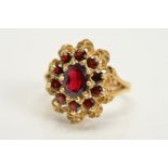 A LATE 20TH CENTURY GARNET CLUSTER RING, head measuring approximately 19.5mm x 16.0mm, ring size