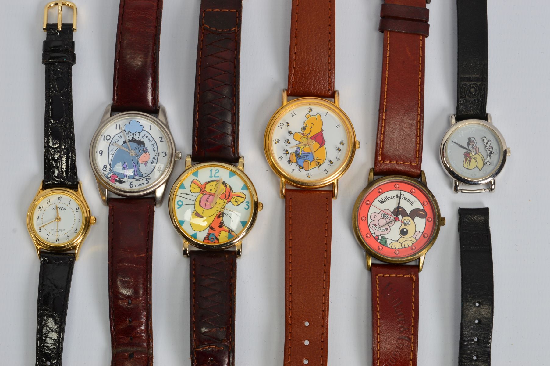 SIX WRISTWATCHES to include watches with faces depicting Winnie the Pooh, Tigger, Eeyore, Cruella De