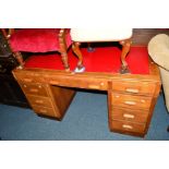 A MID 20TH CENTURY GOLDEN OAK PEDESTAL DESK, red vinyl top and nine various drawers, width 137cm x