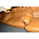 A BROWN LEATHER THREE PIECE LOUNGE SUITE, comprising two two seater settees and an armchair